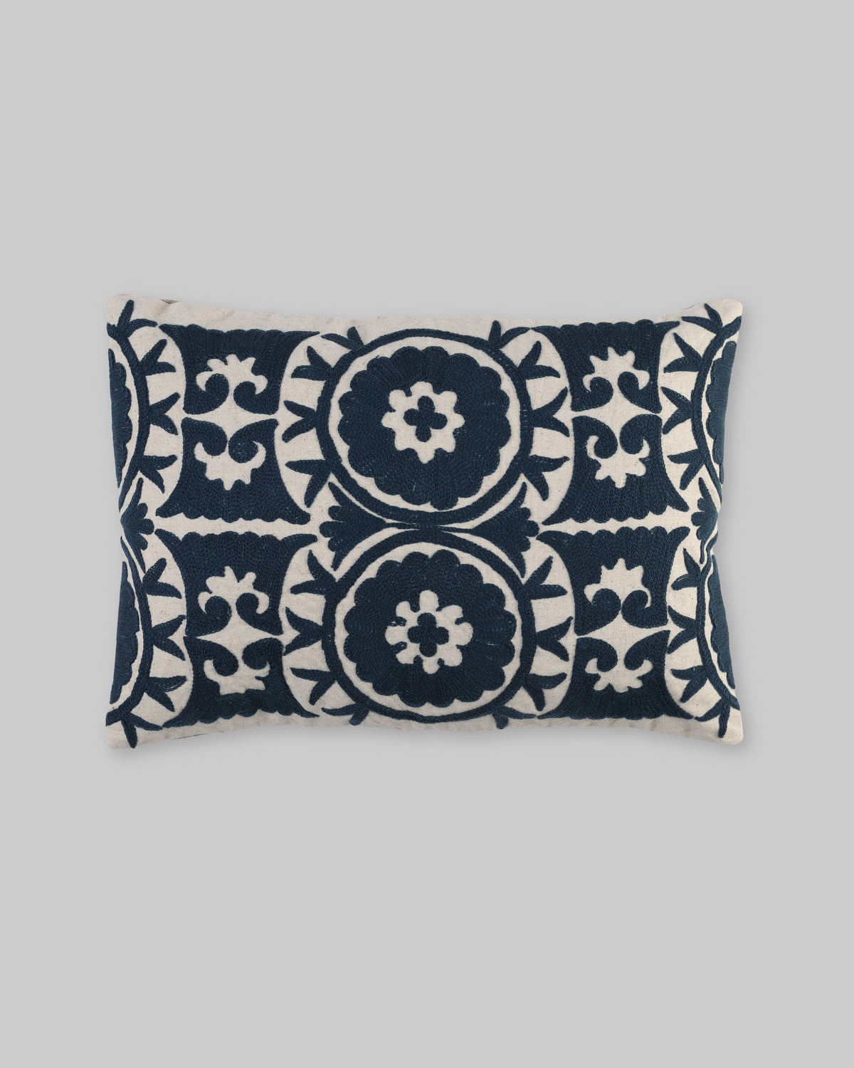 Rectangular pillow cover with navy blue ari-embroidered medallions on ivory