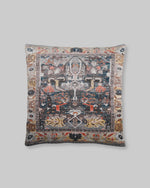 Black slub cotton cushion cover with a faded rug-style print in charcoal, rust and blue