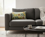 White Dori slub pillow on a charcoal sofa beside a round black coffee table