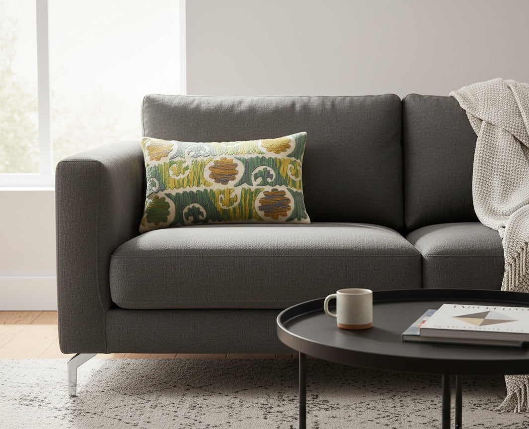 White Dori slub pillow on a charcoal sofa beside a round black coffee table