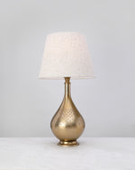 Antique brass dome lamp base styled with a linen shade (shade not included)