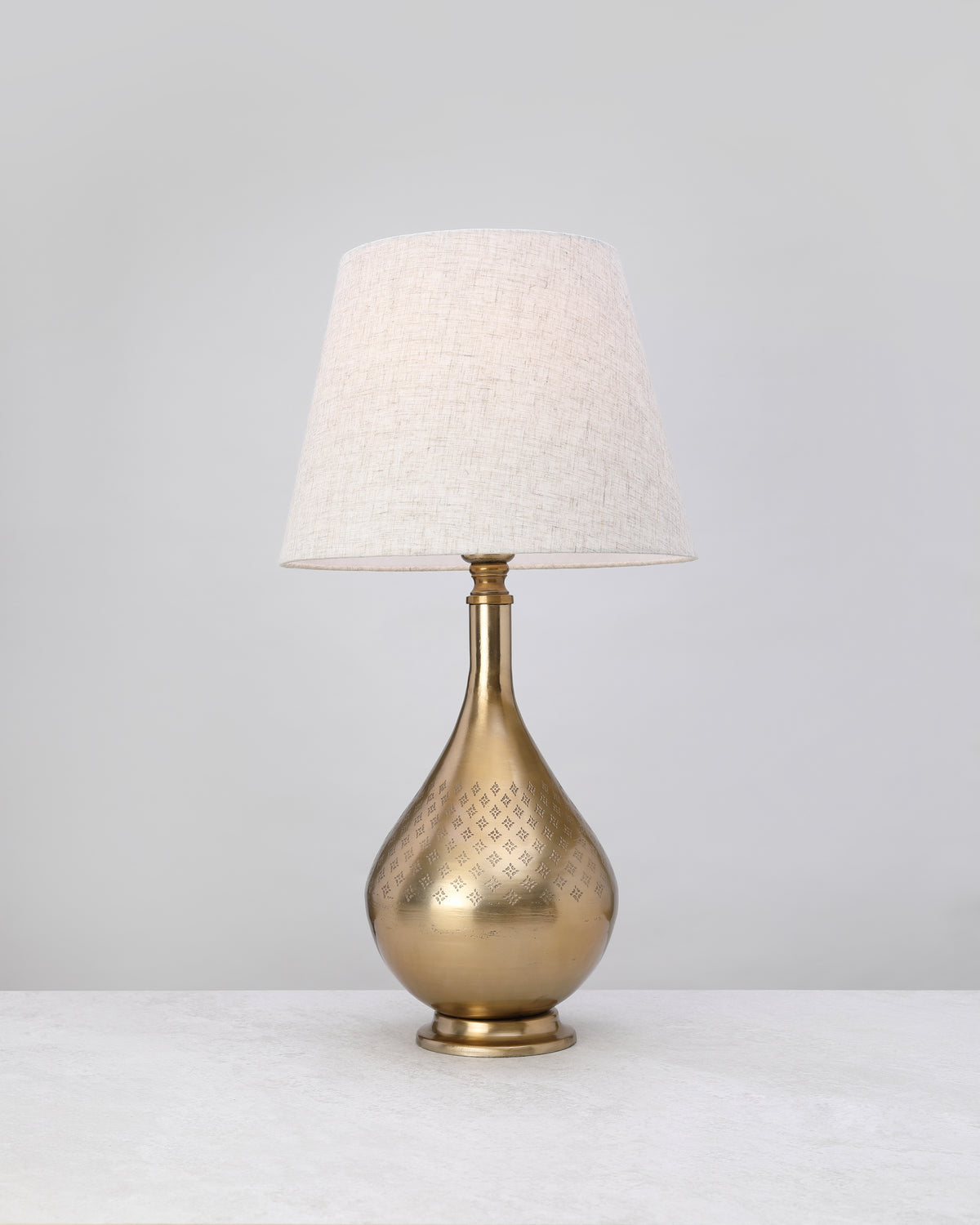 Antique brass dome lamp base styled with a linen shade (shade not included)