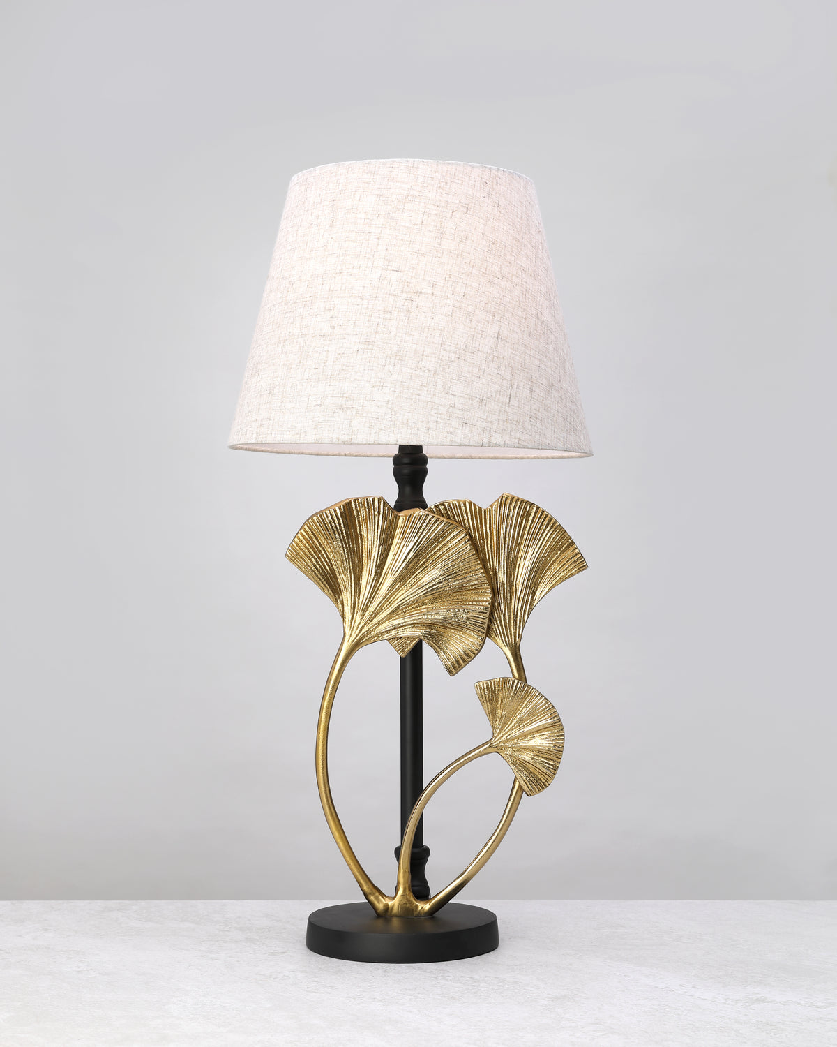 Gilded ginkgo leaf lamp base styled with a linen shade (shade not included)