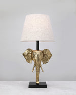 Gilded elephant head lamp base styled with a linen shade (shade not included)