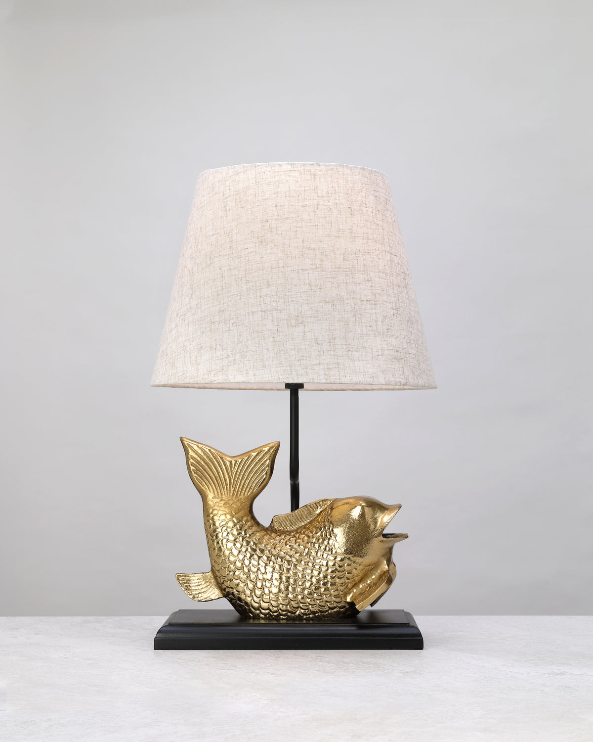 Gilded koi form lamp base styled with a linen shade (shade not included)