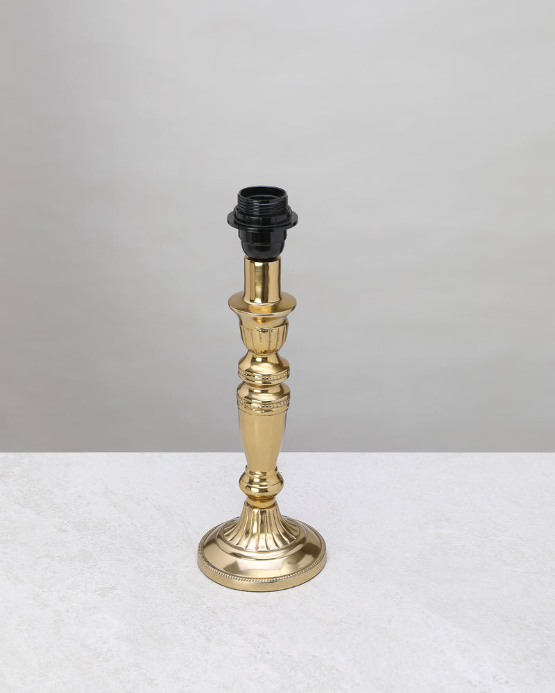 Slender gilded column table lamp base in polished gold, shown without a shade