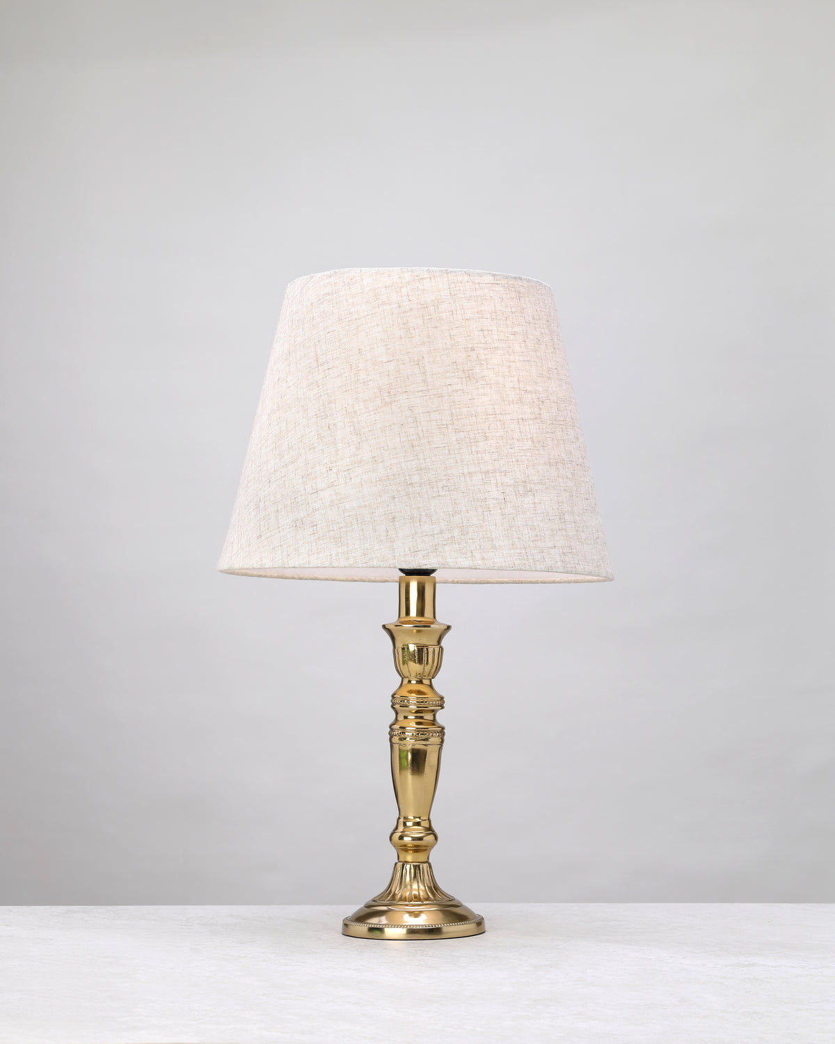 Slender gilded column table lamp with a linen shade