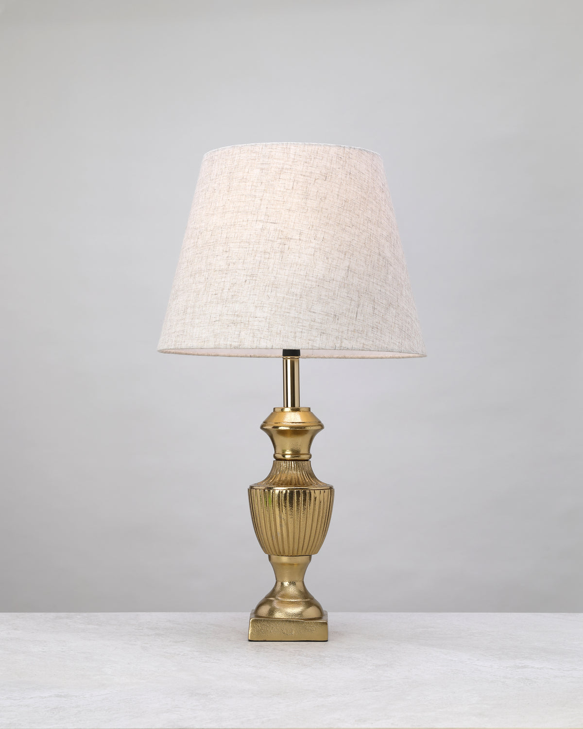 Slim gold reed lamp base styled with a linen shade (shade not included)