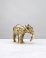 Wide-base gold elephant figure from the other side, showing its tusks