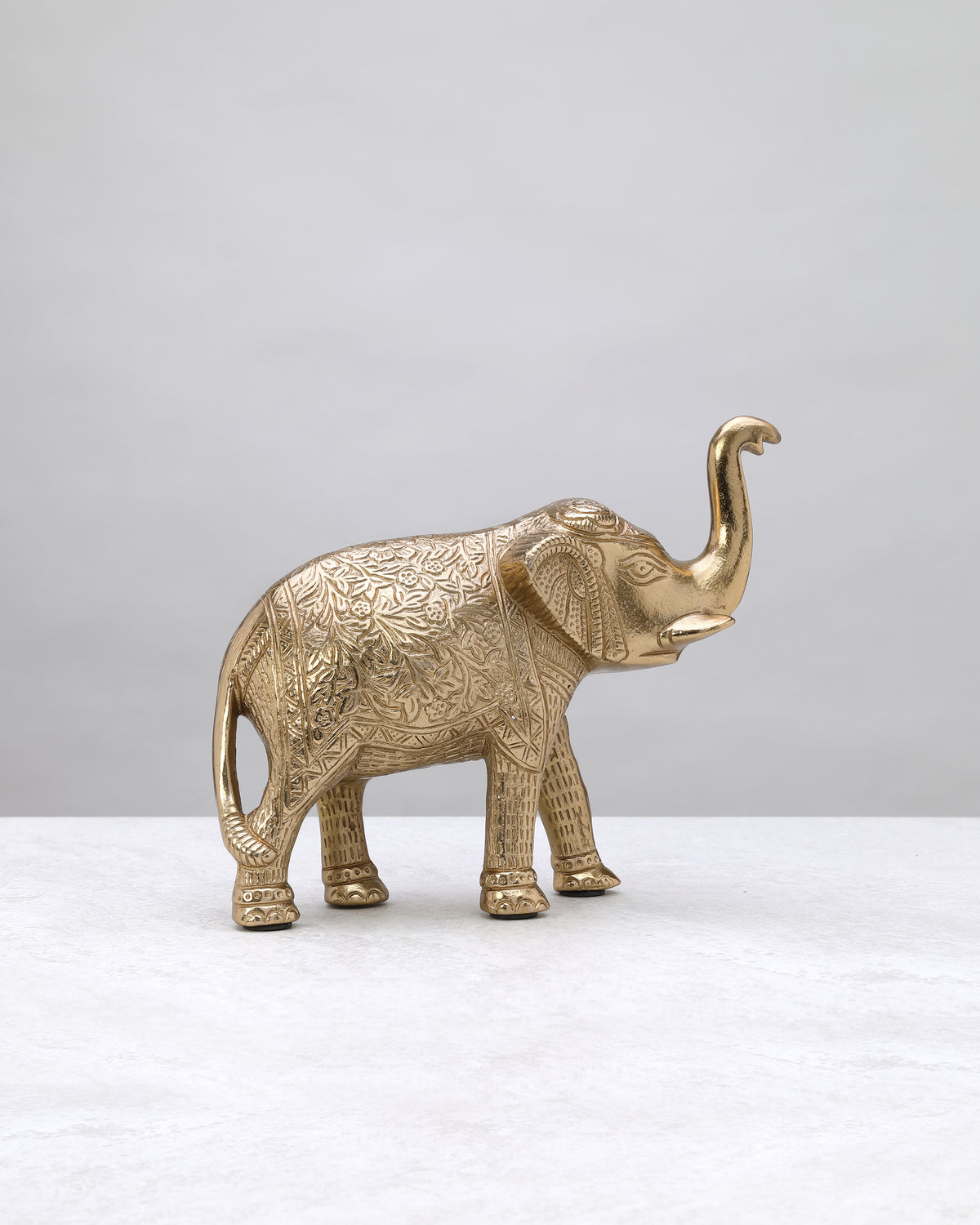 Tall gold elephant figure from the other side, trunk raised