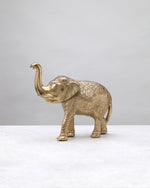 Tall gold elephant figure with a raised trunk and textured body, side view
