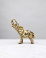 Petite gold elephant figure with a raised trunk and textured body, side view
