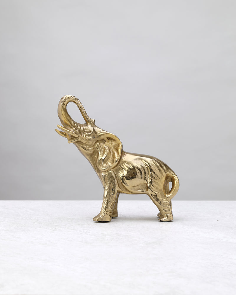 Petite gold elephant figure with a raised trunk and textured body, side view