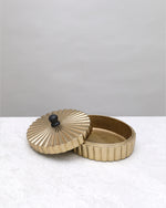 Small gold fluted keepsake box with its lid set beside it, on white
