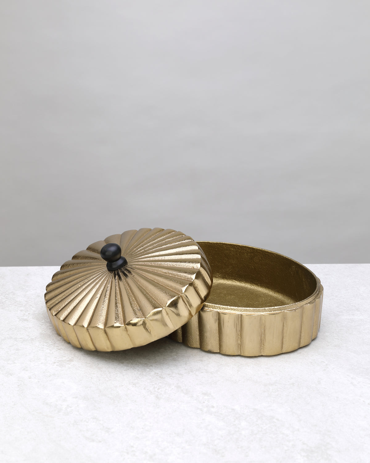 Large gold fluted keepsake box open with its lid beside it, on white