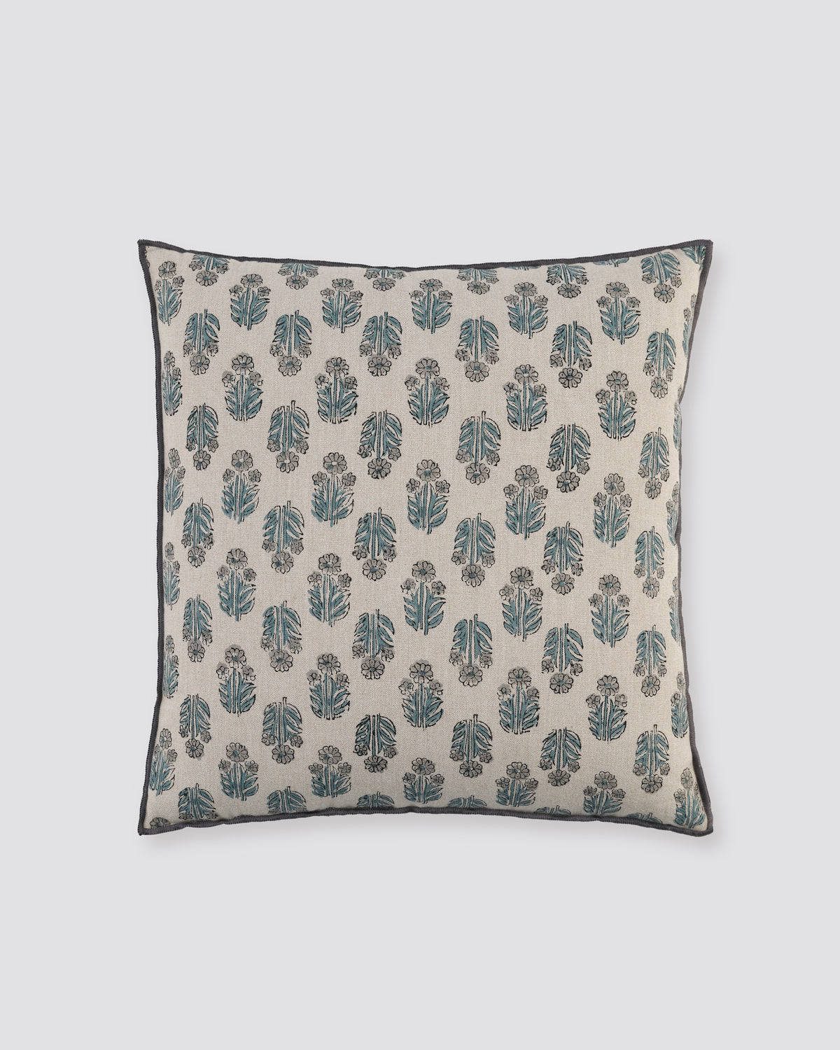 Blue overlock cushion cover with a small blue block-print motif on cream, front view