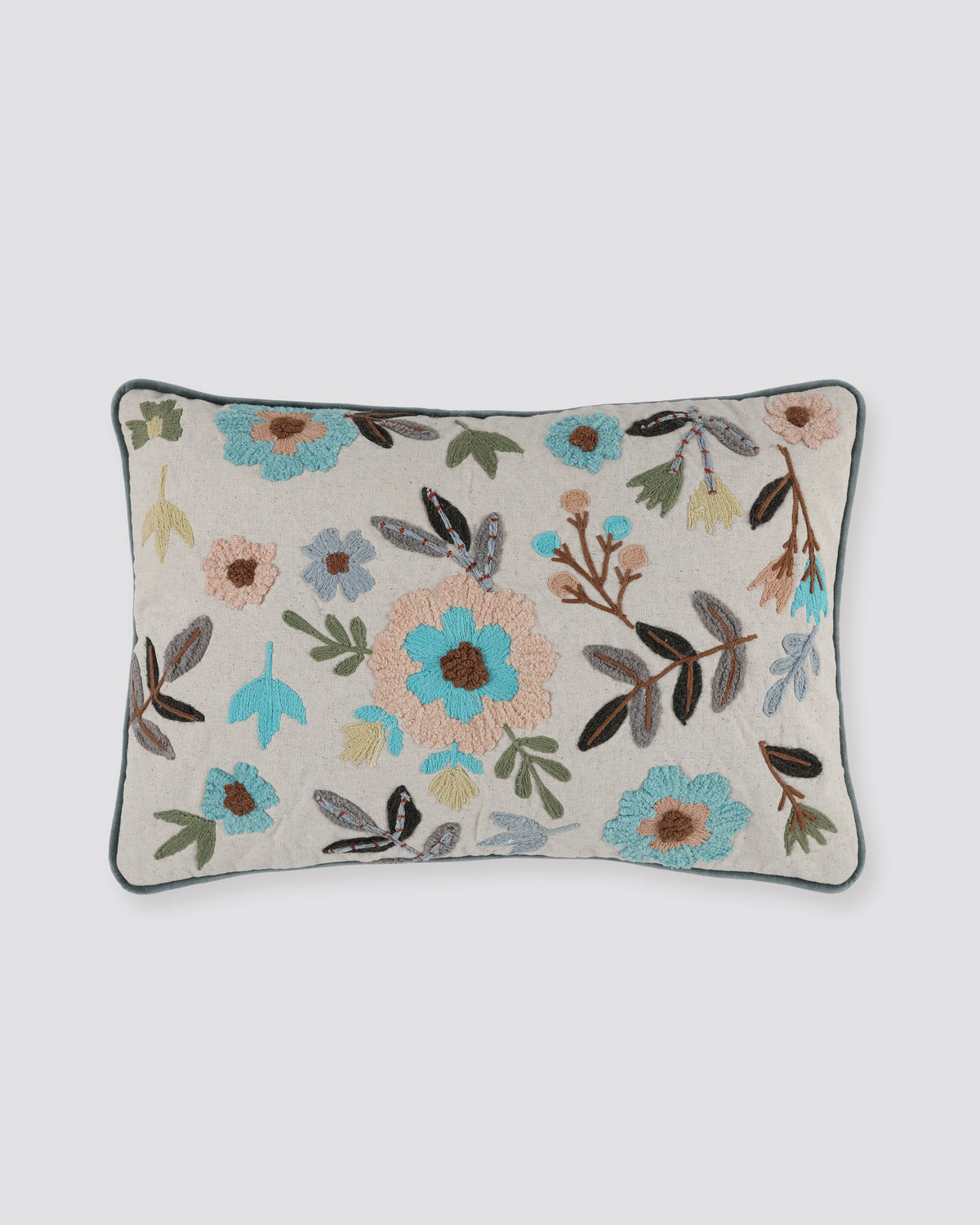 Off white linen pillow cover with tufted blue, grey and peach flowers and a teal piped edge