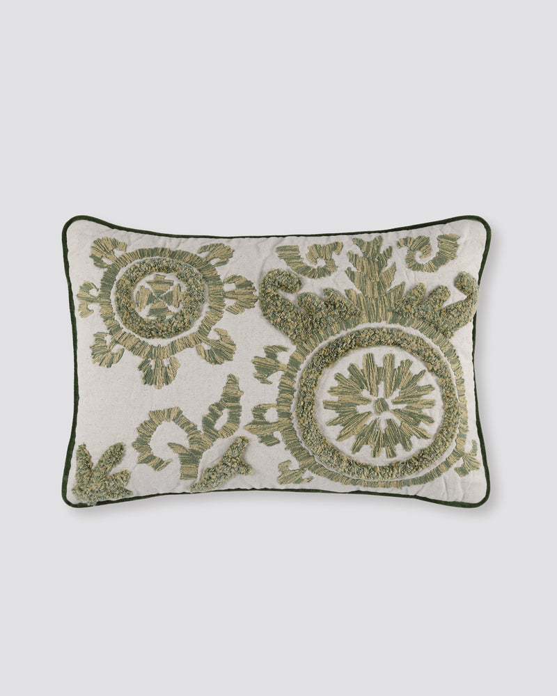Linen pillow cover with green tufted medallion motifs and a dark green piped edge