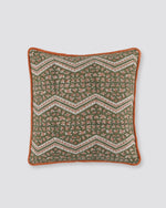Orange piped cushion cover with a green zigzag block print and rust piping, front view