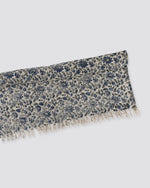 Blue block print cotton dhurrie rug folded, showing the floral print and fringe