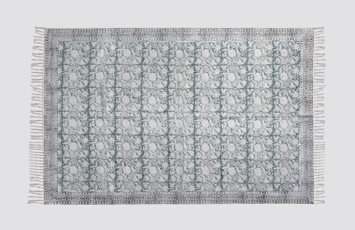 Green and grey block print dhurrie rug laid flat with a geometric tile pattern