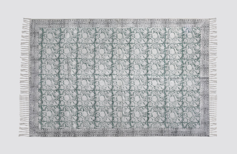 Green and grey block print dhurrie rug laid flat with a geometric tile pattern