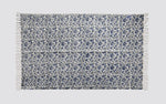 Blue and white block print dhurrie rug laid flat with an all-over floral pattern