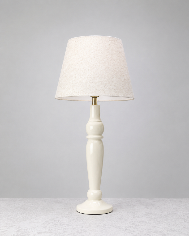 Warm white Sunlit mango wood table lamp with a turned base and linen shade, on white
