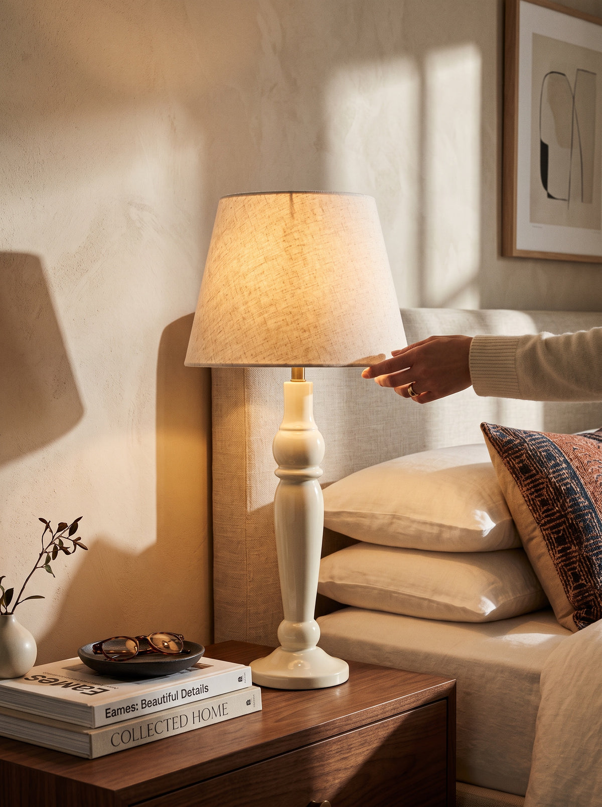 Warm white Sunlit mango wood table lamp with a linen shade glowing on a bedside table