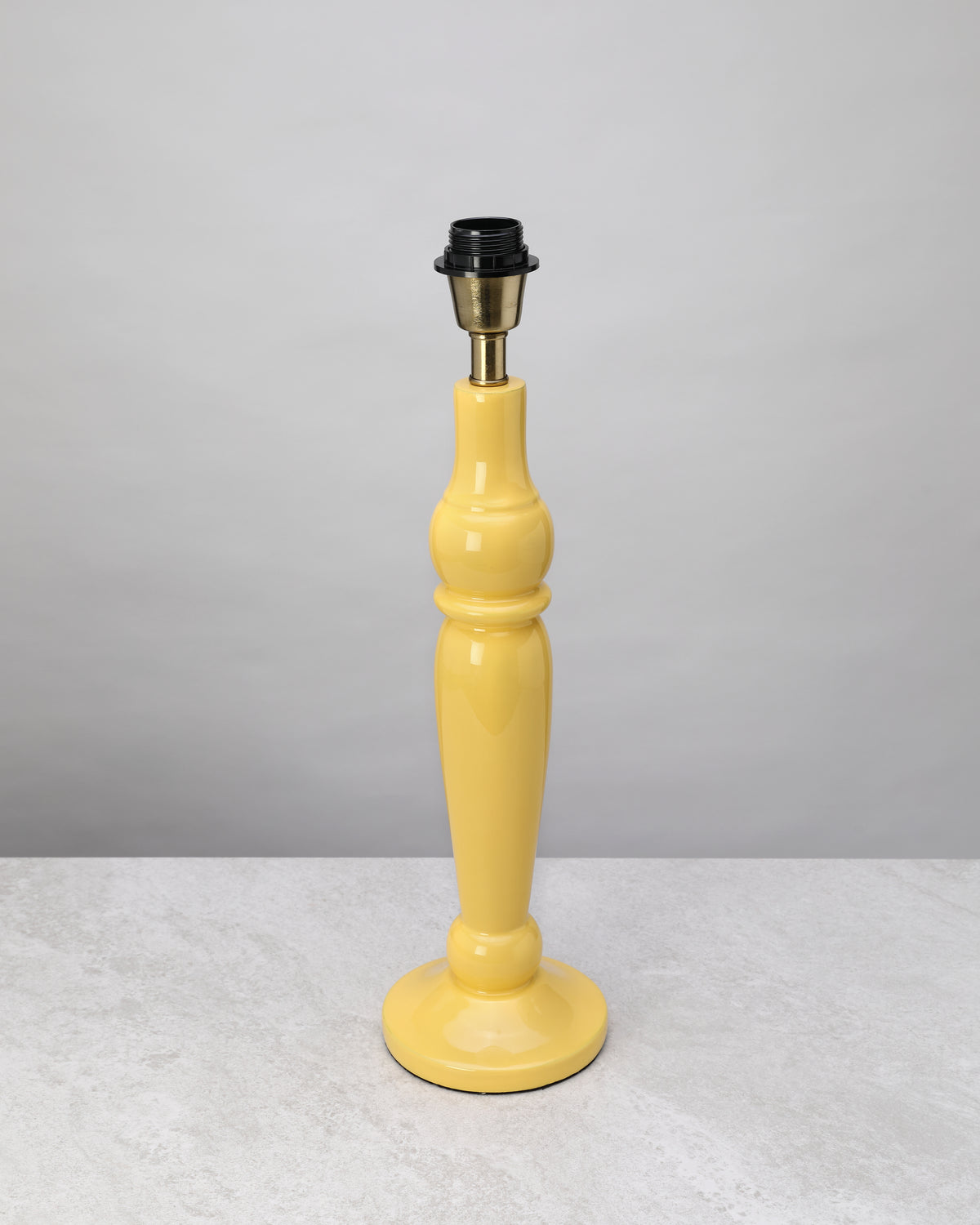 Yellow turned mango wood lamp base shown without its shade