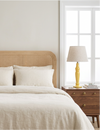 Yellow Sunlit mango wood lamp on a bedside table