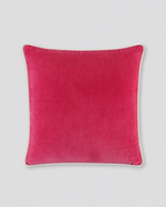 Pink velvet cushion cover with cream piping around the edge, front view