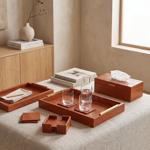 Tan faux leather tissue box with matching trays and coasters on a coffee table