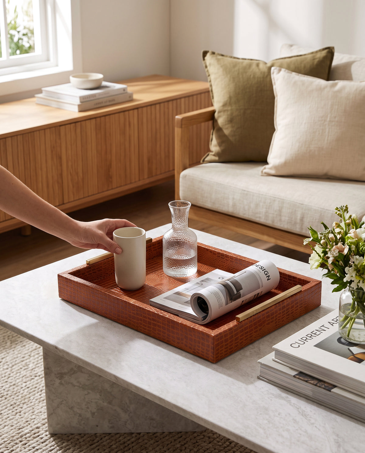 Small tan slim faux leather tray on a marble coffee table holding a cup and magazine