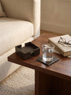 Olive green slim faux leather coasters with a glass on a side table