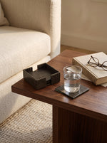 Olive green slim faux leather coasters with a glass on a side table