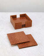 Tan croc-textured faux leather coaster set with its holder, coasters laid in front