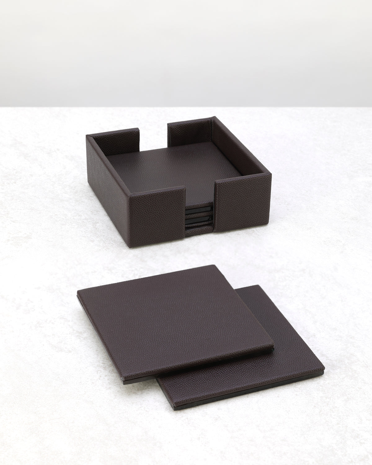 Cherry faux leather coasters laid out beside their holder