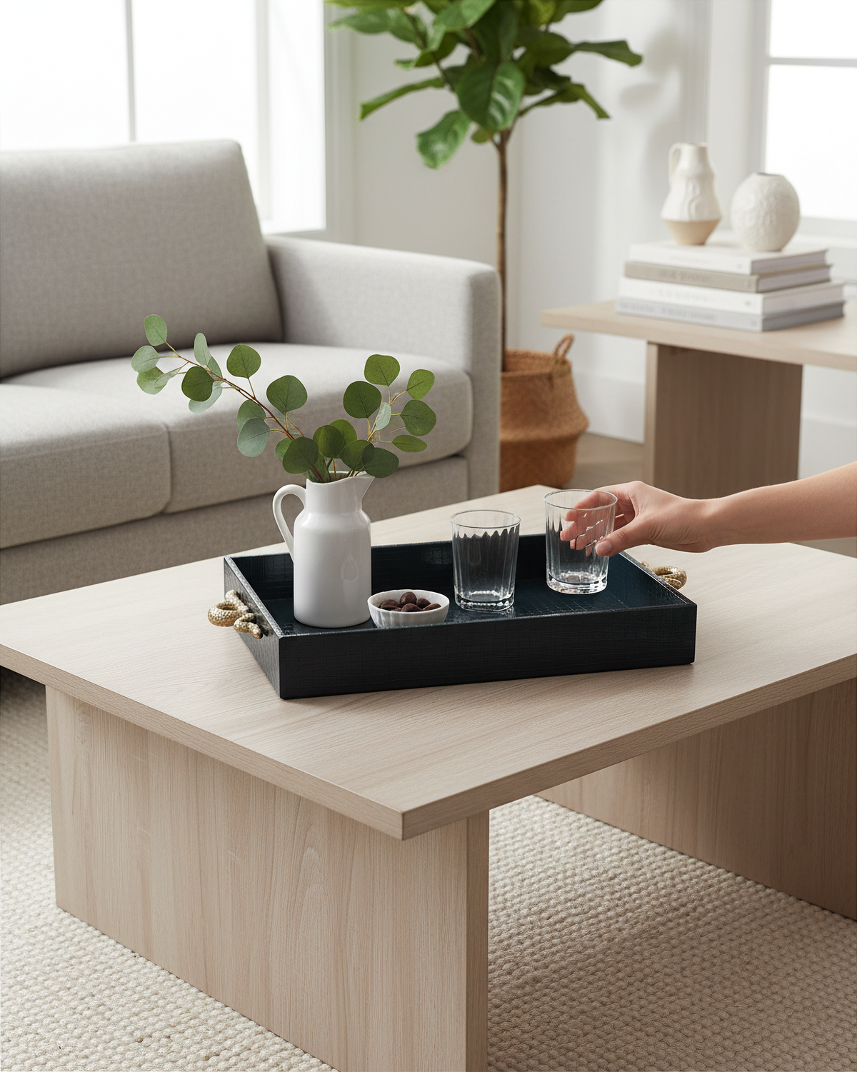 Hand setting a glass on the small navy croco tray on a side table