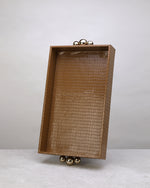 Large beige croco tray standing upright, showing its gold ball feet