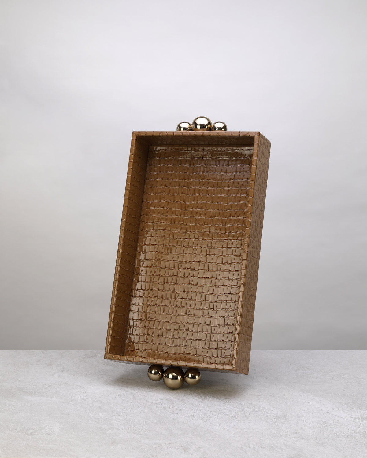 Small beige croco tray standing upright, showing its gold ball feet