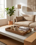 Large beige croco tray holding cups and books on a coffee table in a living room