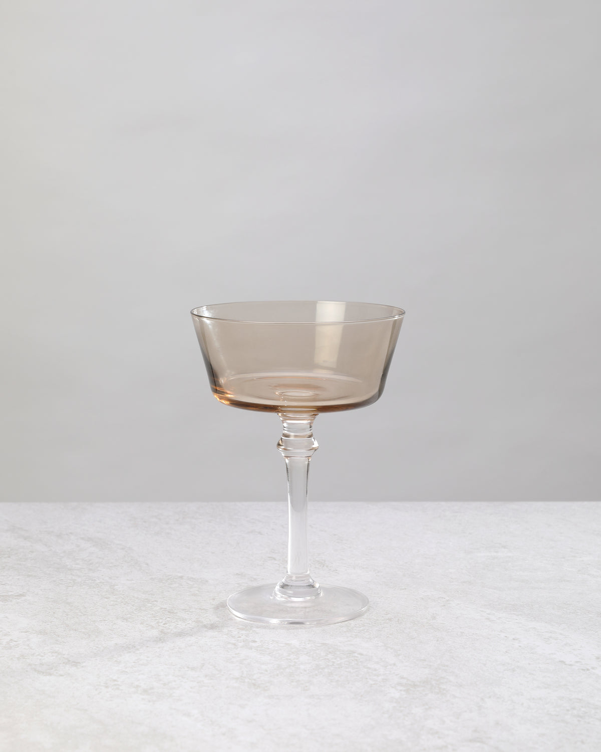 Single coffee-brown coupe cocktail glass, front view