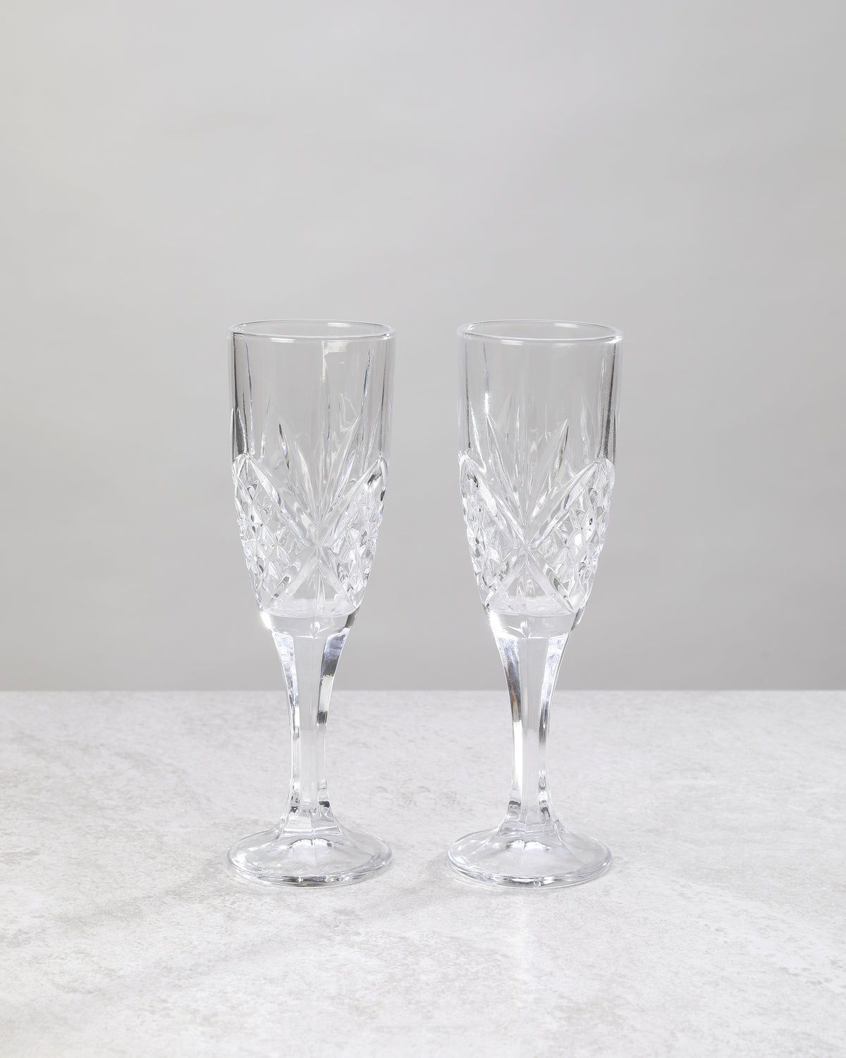 Pair of clear machine cut champagne flutes on a white background