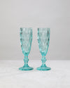 Pair of aqua diamond-cut champagne flutes on a white background