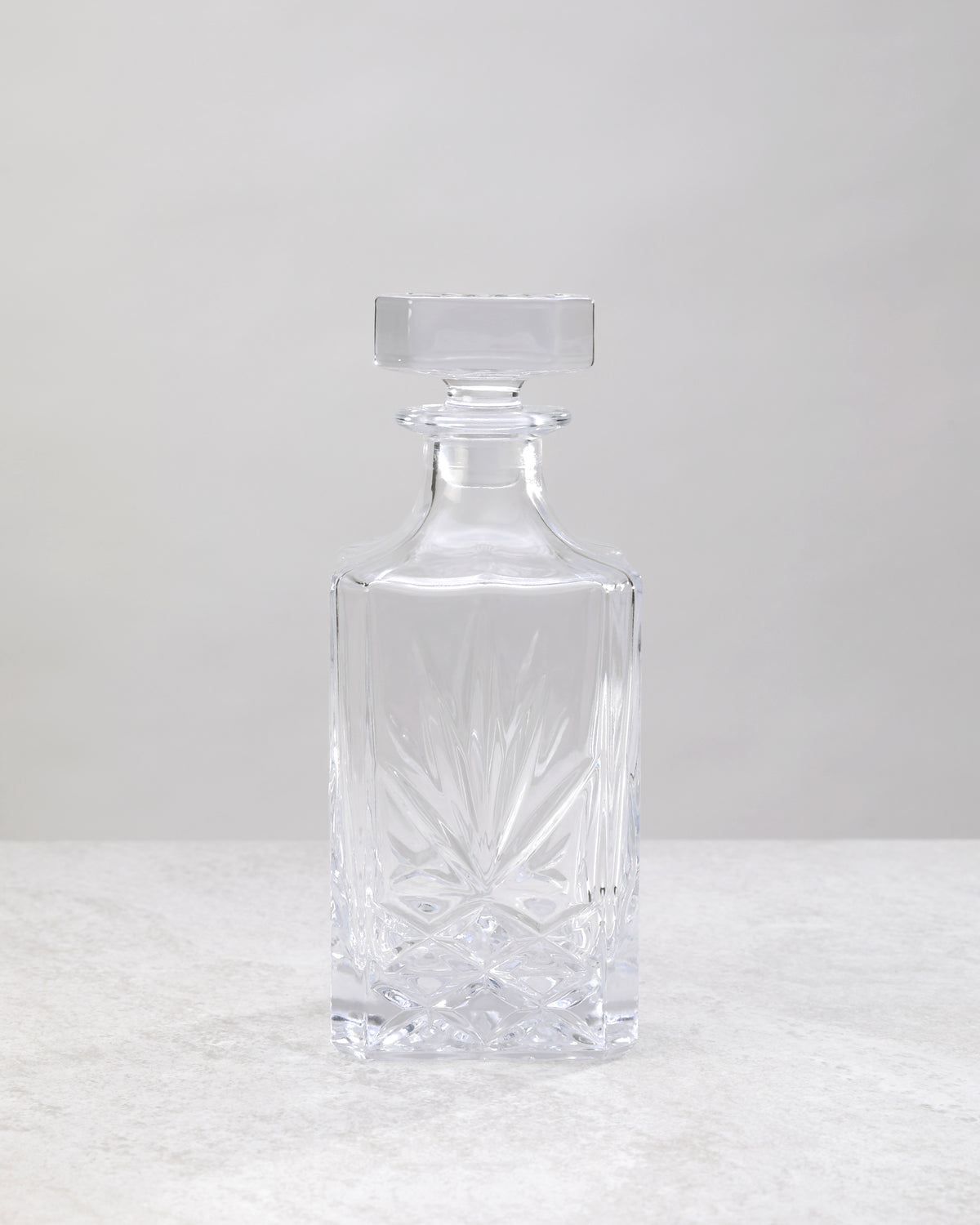 Clear machine cut decanter from the side, showing the cut pattern and stopper