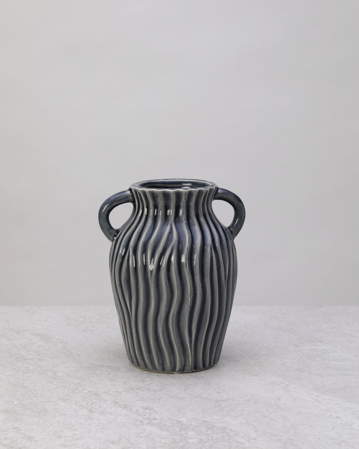 Grey ceramic decorative pot with ribbed sides and two small handles