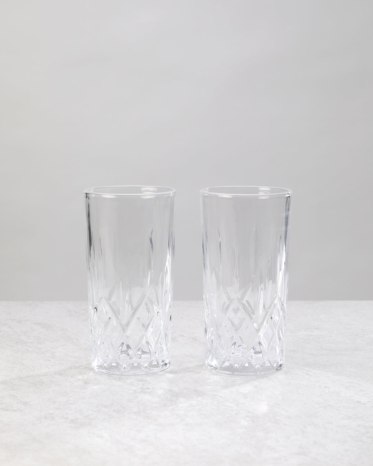Pair of clear machine cut high ball glasses on a white background