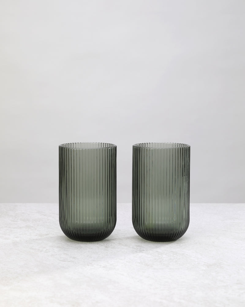 Pair of hunter green ribbed high ball glasses on a white background