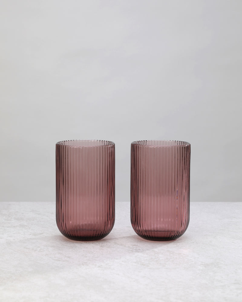 Pair of cordovan ribbed high ball glasses on a white background